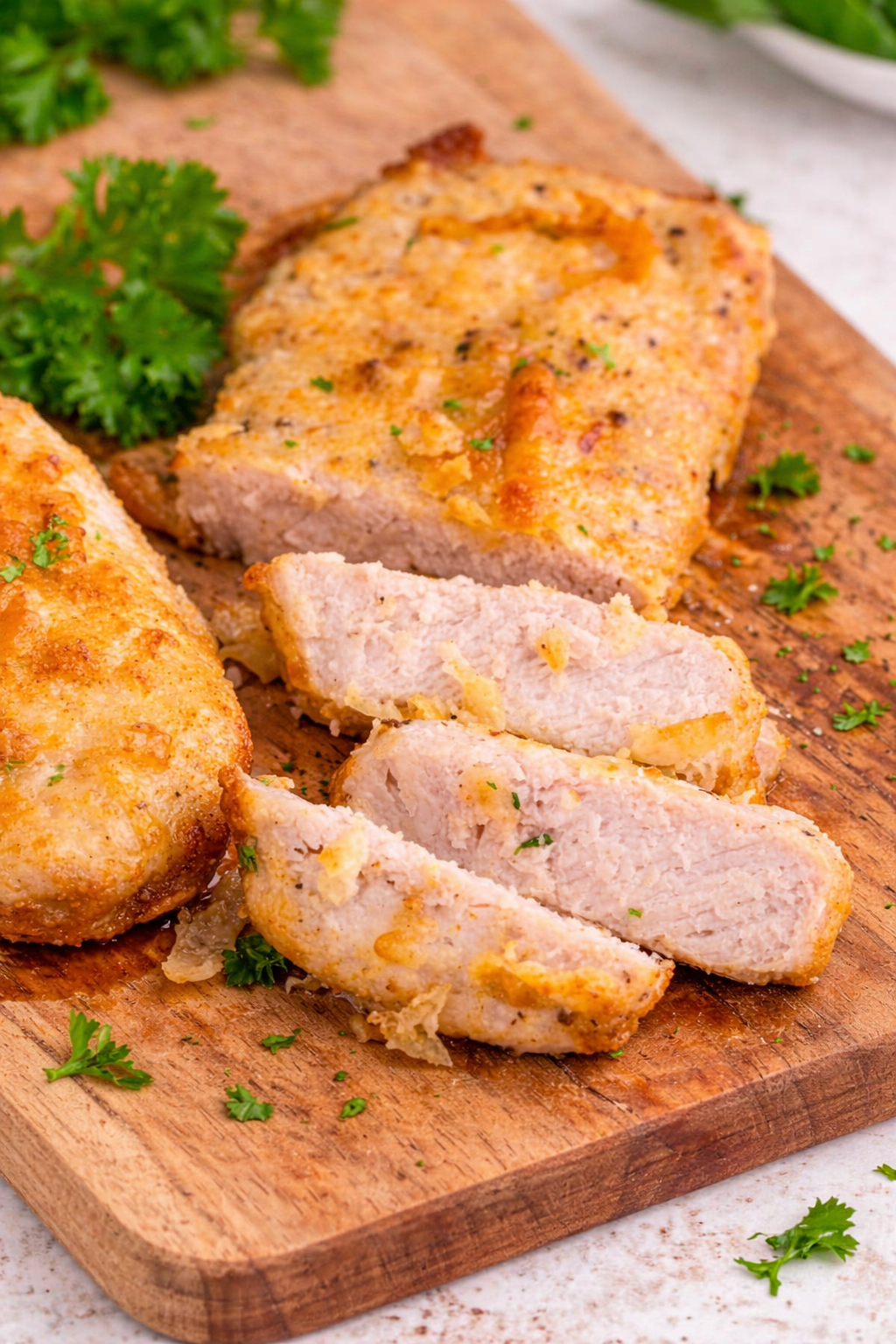 Juicy air fryer boneless pork chops seasoned and cooked to golden perfection, served on a plate with simple side dishes.
