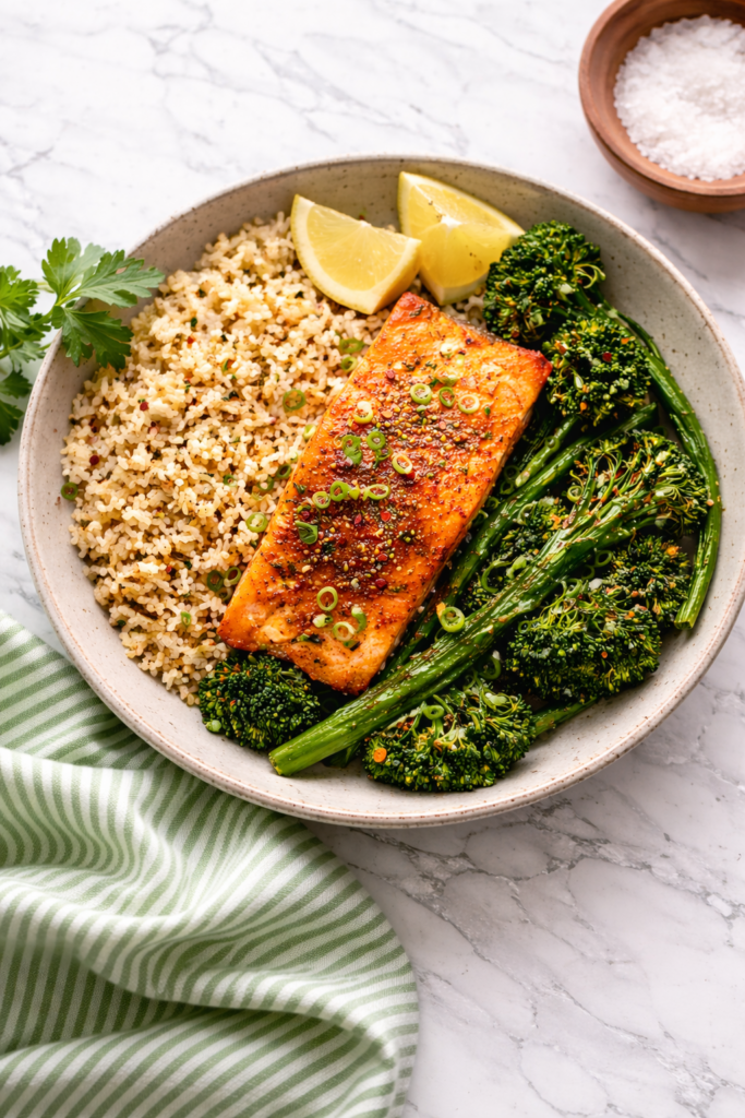 Salmon fillets cooked in an air fryer, seasoned and golden on a white plate.