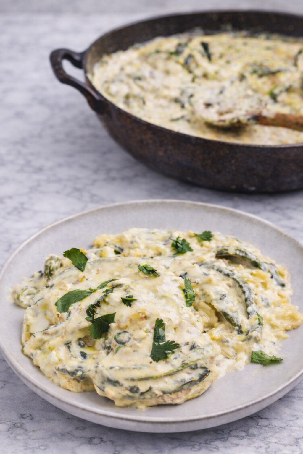 Creamy rajas poblanas con pollo served in a skillet with roasted poblano pepper strips, tender chicken pieces, and a rich velvety sauce, garnished with fresh herbs and vibrant Mexican flavors.