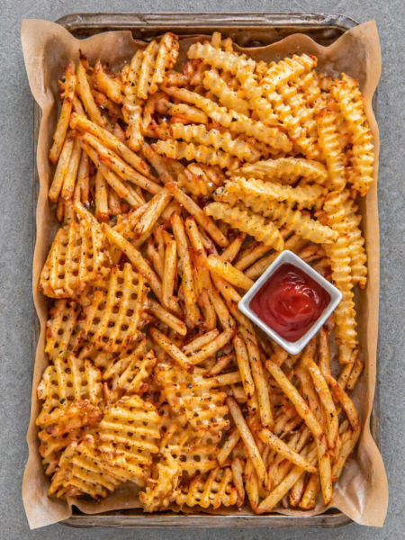 Crispy golden air fryer frozen French fries served in a white bowl on marble countertop