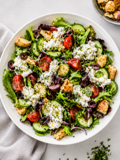 Creamy burrata salad with tomatoes, basil, olive oil, and balsamic glaze on a serving platter