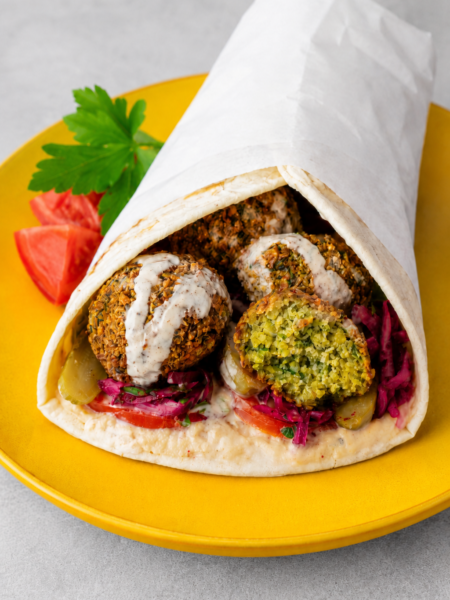Falafel Wrap filled with crispy falafel, lettuce, tomato, cucumber, and creamy tahini sauce in warm flatbread.