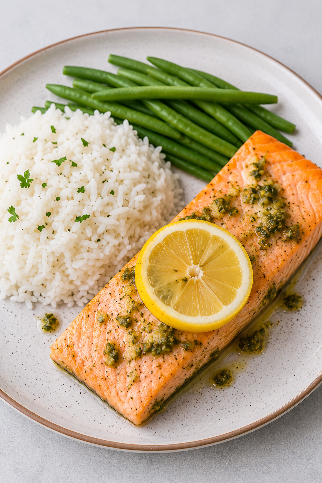 Oven baked salmon fish fillet glazed with garlic Dijon sauce and garnished with lemon slices and herbs.