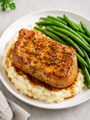 Tender slow cooker pork chops covered in creamy onion gravy and garnished with fresh parsley